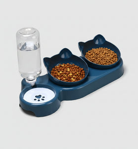Pet feeding station with two bowls of food and a glass of water on an orange background