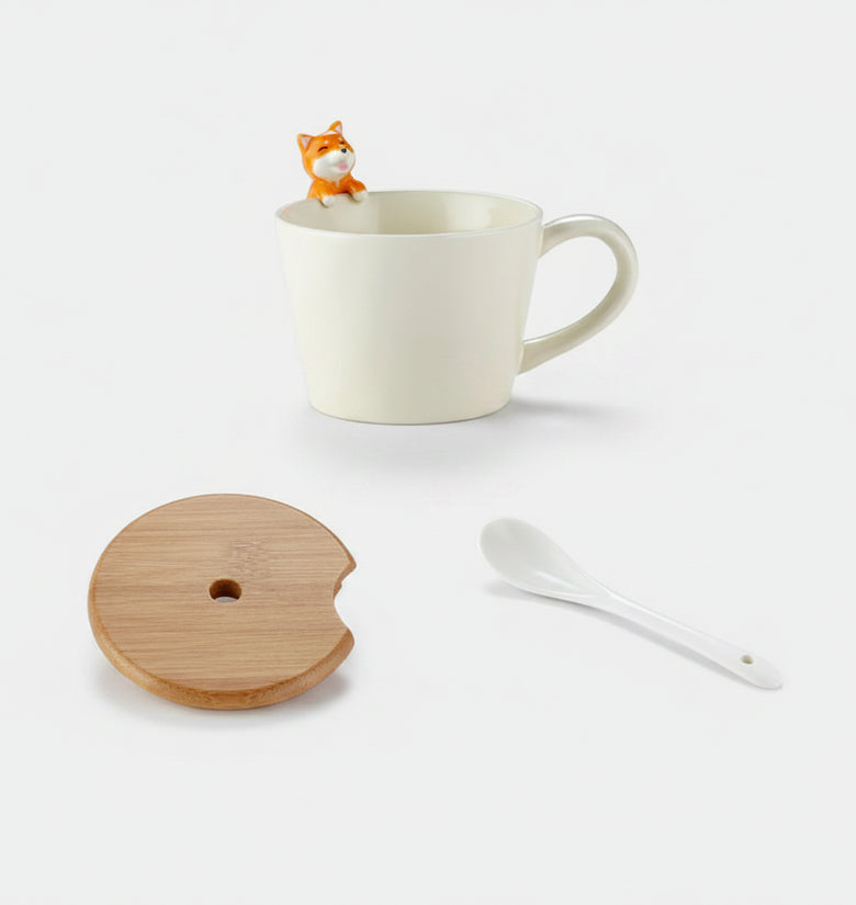 White mug with a small fox figure, wooden coaster, and white spoon on a white background