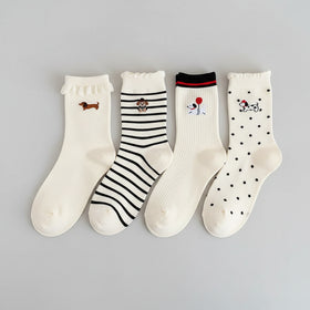 Set of white socks with cartoon designs on a beige surface