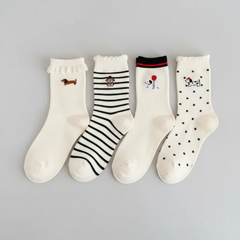 Set of white socks with cartoon designs on a beige surface