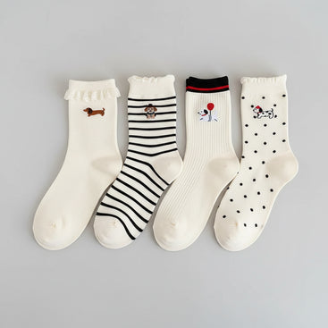 Set of white socks with cartoon designs on a beige surface