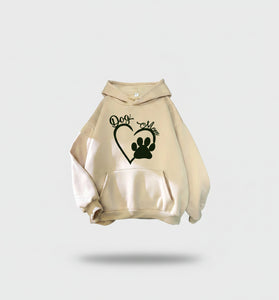 Beige hoodie with 'Dog Mom' and paw print design on a textured surface.