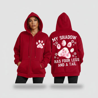 Red hoodie with paw print design and text, worn by a person.