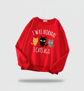 Red sweatshirt with cat illustration and text on a newspaper background