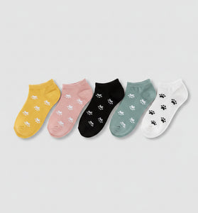 Four pairs of socks in yellow, black, gray, and pink with paw prints on a white background.