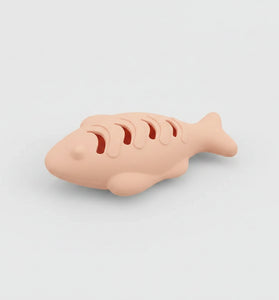 Cat playing with a silicone toy shaped like a fish, with text on both sides.