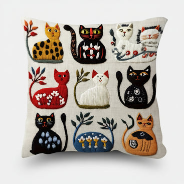 Decorative pillow with embroidered cats in various colors on a white background